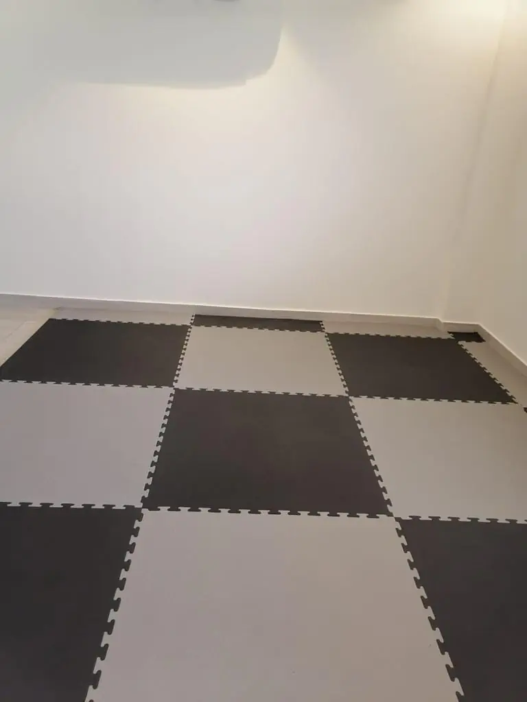 غرفة مفروشة ببلاط فوم متداخل رمادي وأسود